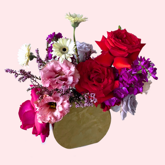 A Fun and Vibrant designer's choice mix featuring mix of colorful blooms in a modern large gold bud vase